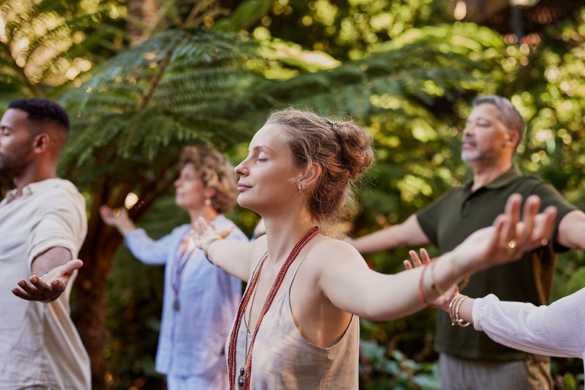 Grupo practicando meditación y sanación en un bosque